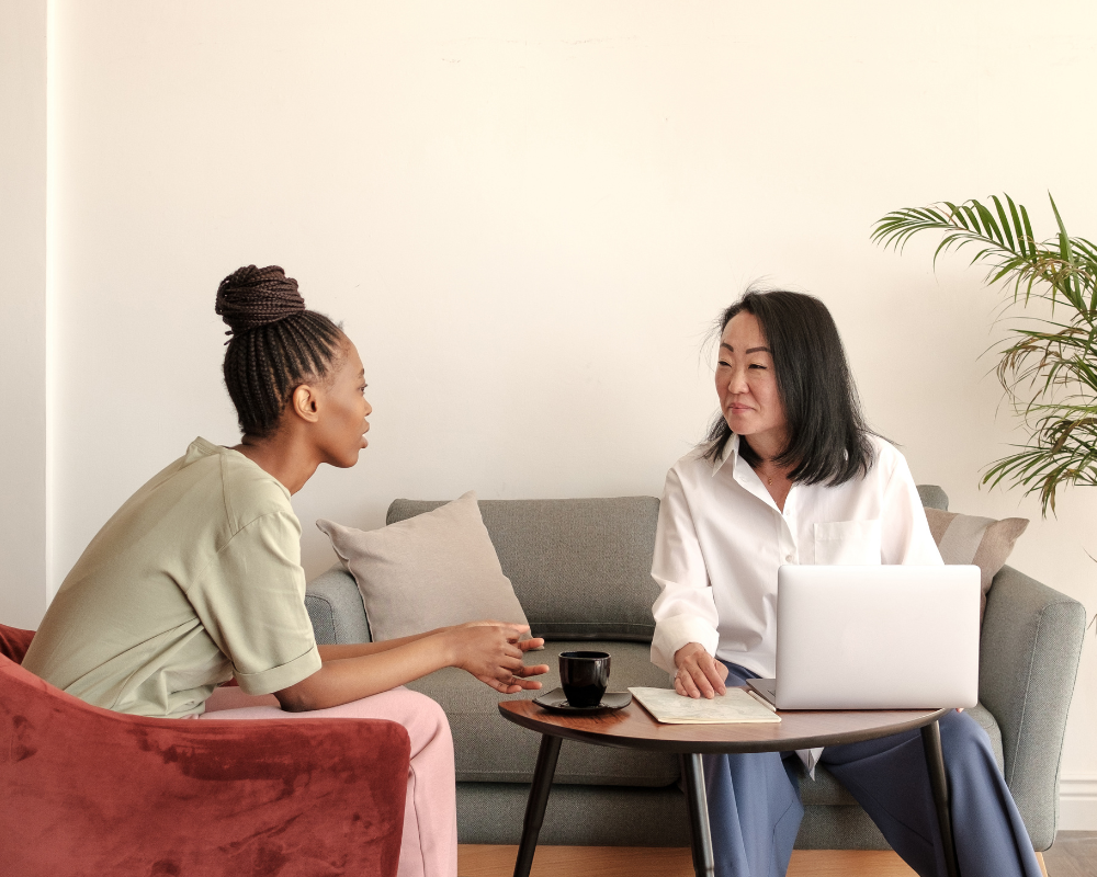Two women sitting together talking in a counseling setting