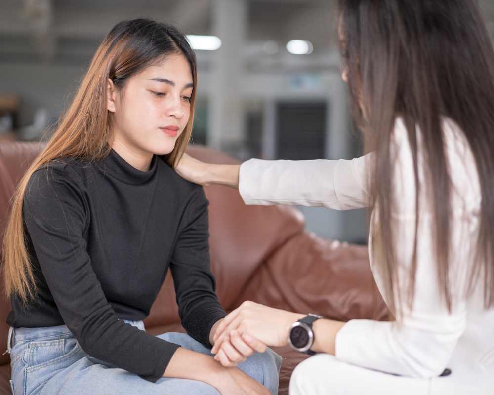 A young girl being supported by a counselor